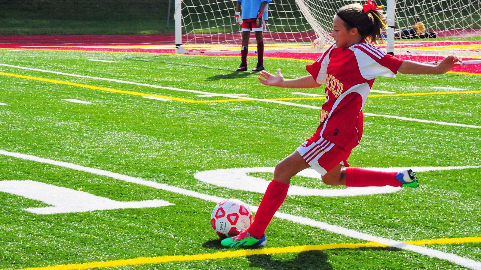 Footballer shooting at a goal net